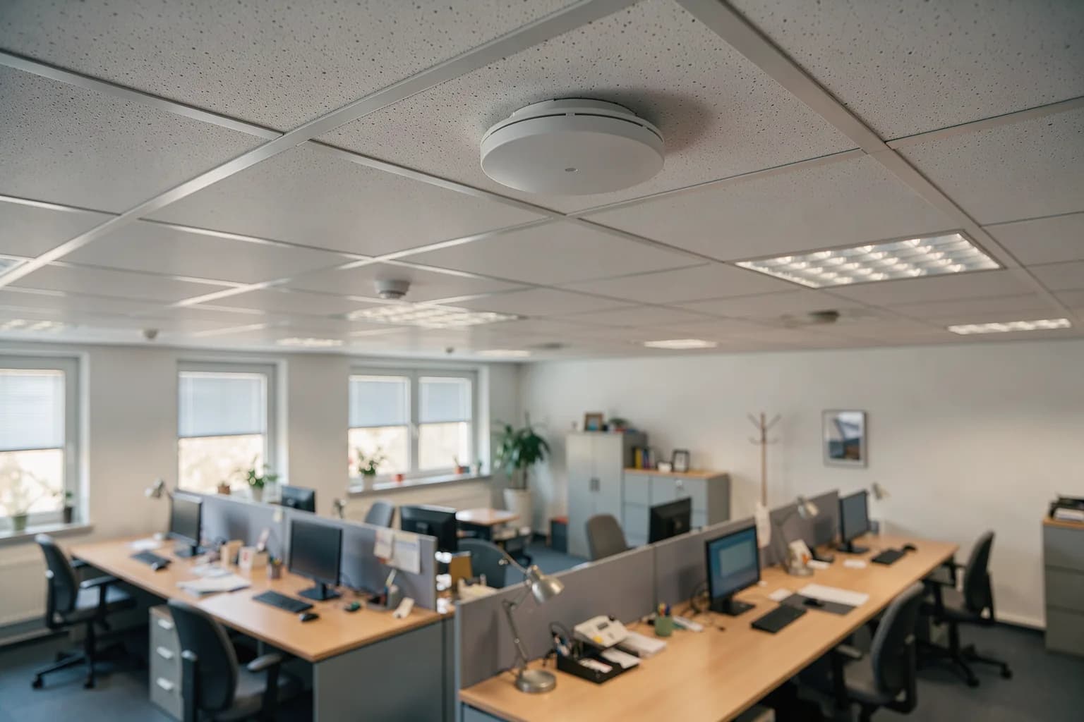 An der Bürodecke montierter Access Point, darunter ein Großraumbüro mit Arbeitsplätzen