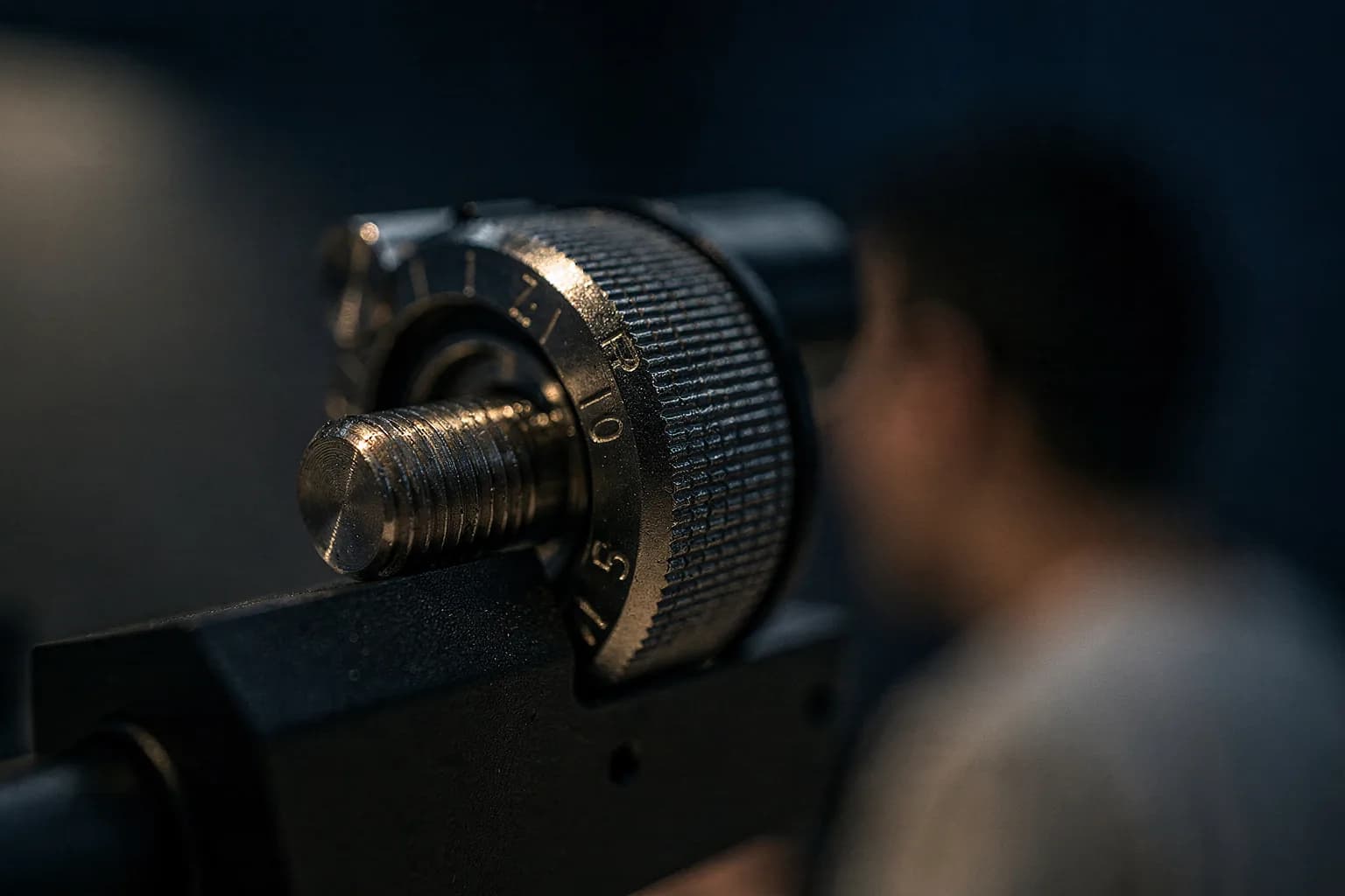Sehr nahe Aufnahme einer Mikrometerschraube an einer optischen Halterung mit feiner Gravur, sehr geringe Schärfentiefe