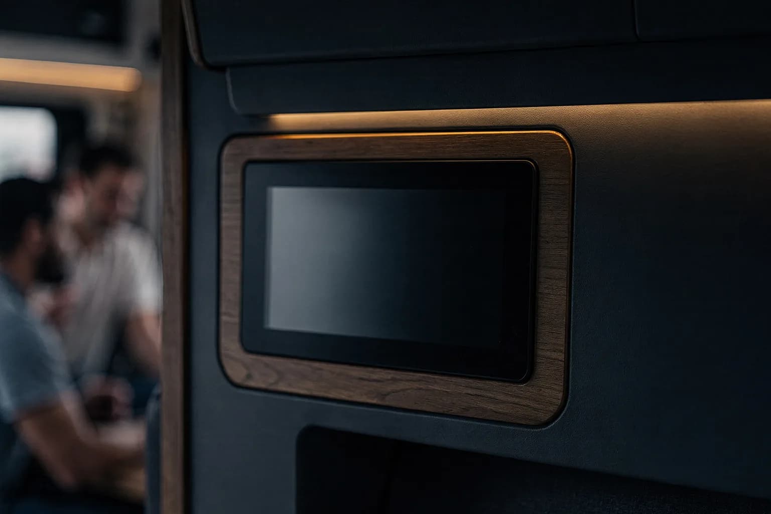 Bedienpanel für den Wohnaufbau im Inneren eines Reisemobils mit leerem Display, Holzdekor, warmes Innenlicht